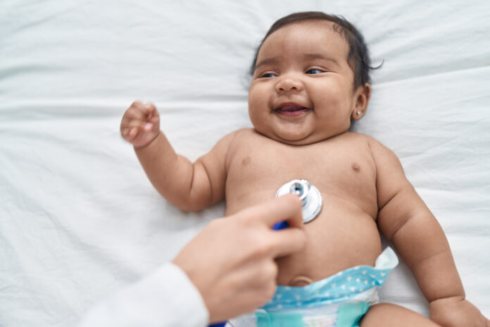 African american baby smiling confident having medical examination at bedroom