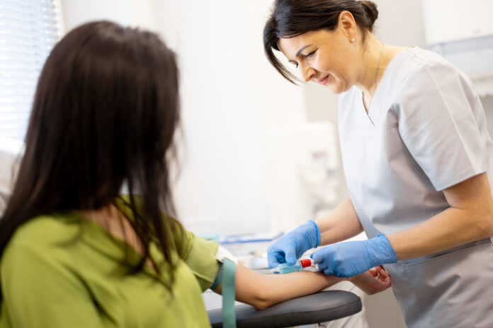 Nurse takes blood test of a young woman in laboratory Fertility Check